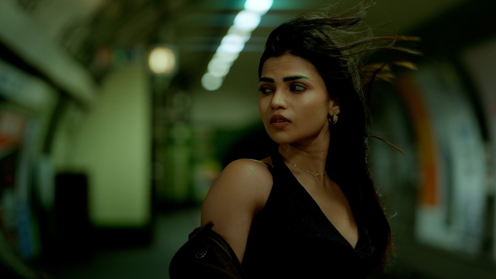 Graded frame: woman on an Underground platform in deep greens and warm skin tones