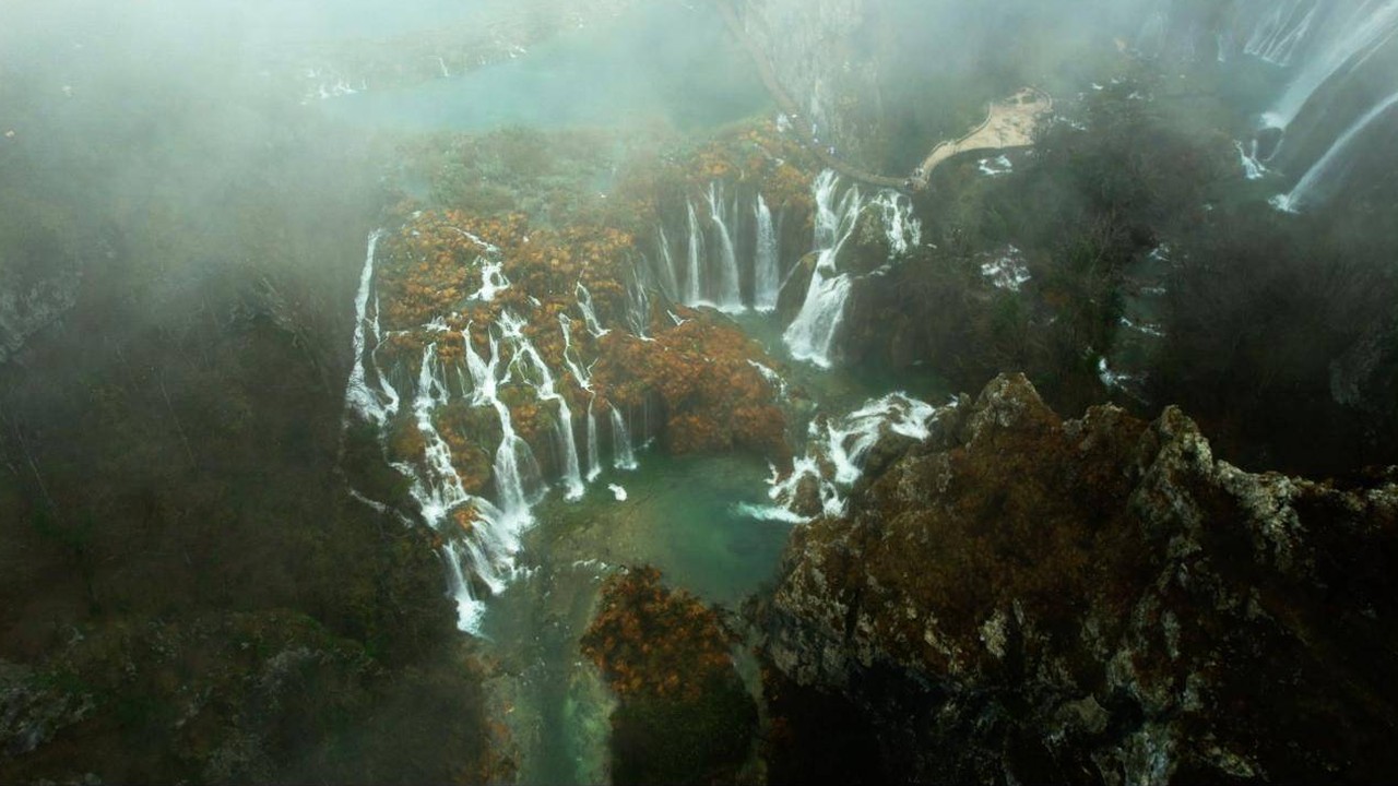 Aerial view of misty waterfalls and autumn trees in Croatia